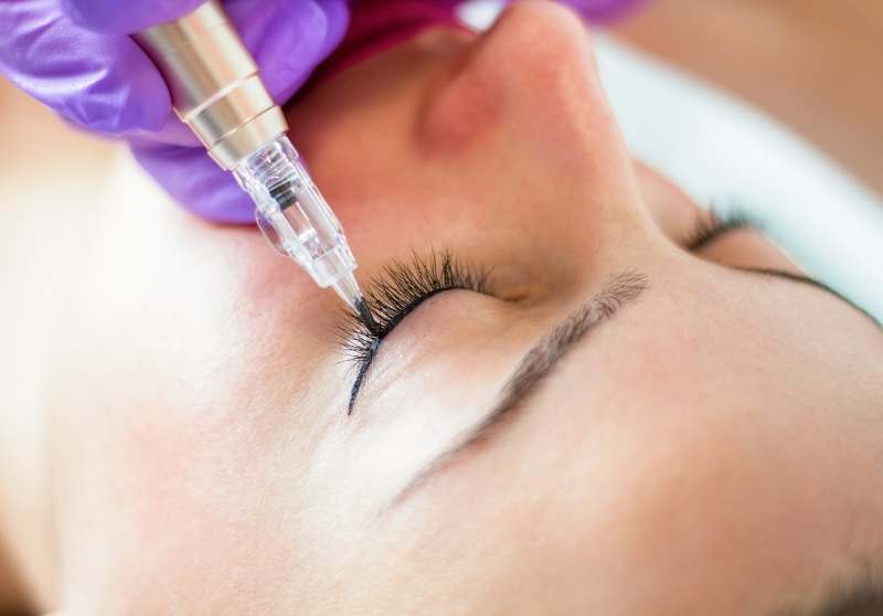 woman undergoing a permanent eyeliner tattoo procedure