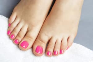 closeup of toes on a towel with pink nail polish