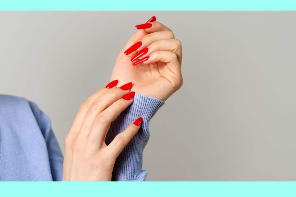 close up of a woman's hand with red nails