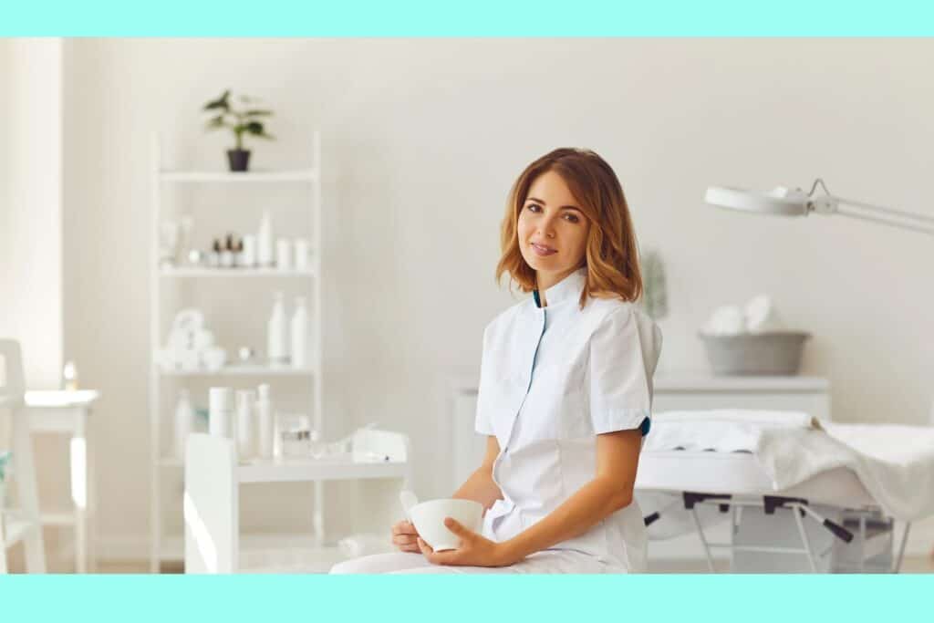 female beauty therapist sitting in her treatment room with a bowl in her hand